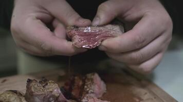 The chef squeezes the juice from a piece of meat onto the cooked steaks lying on the cutting board video