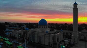 A drone flies around a mosque in the city against the background of Sunrise. video