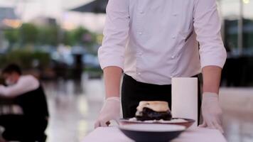 A waiter rolls a table with food in a restaurant under the open sky video