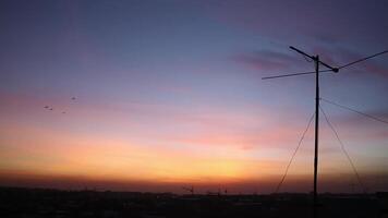 Zeitraffer Schießen von Sonnenaufgang auf Häuser im das Stadt. im das Vordergrund auf das Dächer von das Antenne. video