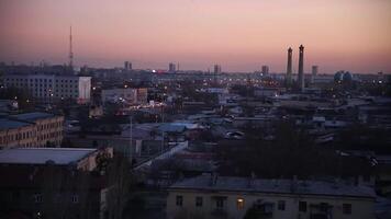 hermosa rosado puesta de sol terminado el ciudad. un televisión torre lata ser visto en el distancia. video