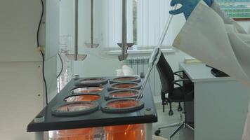 Laboratory technician in protective clothing taking chemical samples from automatic mixer in laboratory video