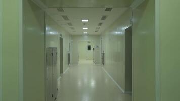 People in protective clothing of chemists walking down the corridor of the laboratory video