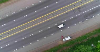 Drönare flugor över ett asfalt väg med godkänd bilar. video
