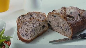 detailopname van gesneden rogge rozijn brood Aan de wit snijdend bord video