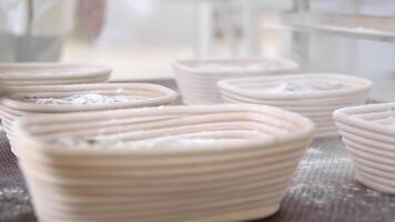 Bakers sprinkle flour a lot of ready-to-bake breads that lie on the table video