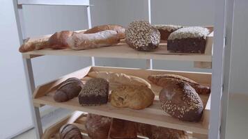 Fresh baked long baguette breads lie on the wooden table sprinkled with flour in a pile video