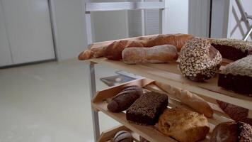 färsk bakad lång baguette bröd lögn på de trä- tabell stänkte med mjöl i en lugg video