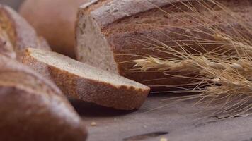 Kamera ist Zoomen durch geschnitten und ganze Weizen Brot und Weizen Ohren zu das Lehm Töpfe video