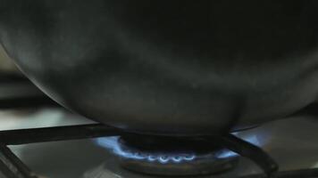 un' ardente fuoco su un' gas frusta sotto un' calderone. video