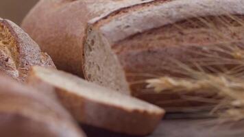 Camera is zoom through sliced and whole wheat bread and wheat ears to the clay pots video