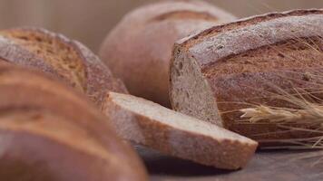 Kamera ist Zoomen durch geschnitten und ganze Weizen Brot und Weizen Ohren zu das Lehm Töpfe video