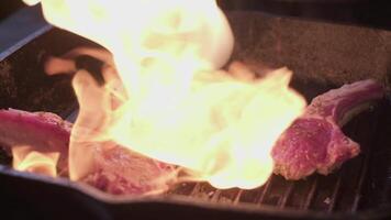 Lamb ribs in spices on a grill are being flamed by gas burner video