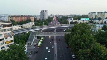 Tashkent, Uzbekistan - 7 9 2023. The drone flies over the roads and highways of the city with moving cars. Overcast summer day video