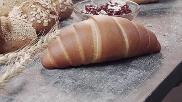 detailopname van verschillend types van vers gebakken Nederlands brood is Aan de houten tafel video