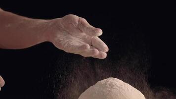 Male hands sprinkle a piece of baking dough with flour video