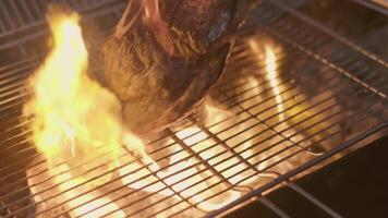 Close-up of big stake grilled on the big open fire and turned with tongs video