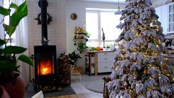 metall svart spis, brinnande härd öppen spis i vit festlig interiör av hus är dekorerad för jul och ny år, jul träd. ved i de vedtrave, mysigt och uppvärmning av Hem video