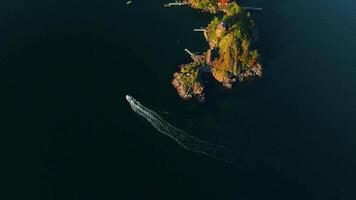 Top down view of motor boat sails around the coast of the island video