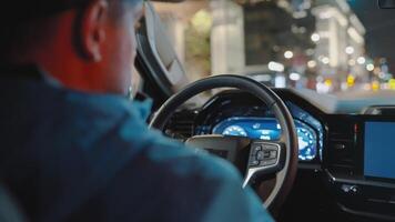 hombre conducción coche mediante el calles de noche ciudad. video