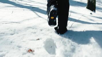 Person slowly walking in the snow with boots leaving traces video