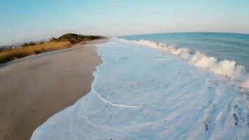 Rough waves of sea during winter season crashing on the beach fpv aerial video