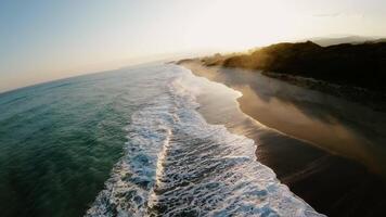 golven van winter oceaan crashen Aan de kust gedurende susnet video