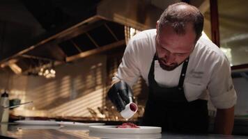 Chef pours raspberry sauce on tuna carpaccio video