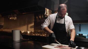 Italiaans chef snijdend vis voor tweede Cursus bruiloft voedsel in keuken video