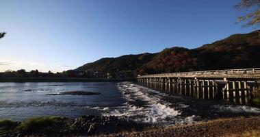 uma alvorecer do togetsukyo ponte perto katsuragawa rio dentro Quioto dentro outono Largo tiro panning video