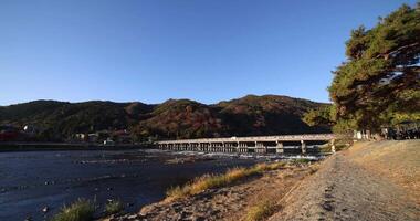 Togetsukyo bridge near Katsuragawa river in Kyoto in autumn wide shot video