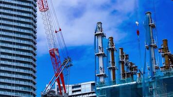 A timelapse of crane at the under construction in Tokyo telephoto shot zoom video