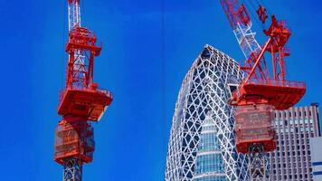 A timelapse of crane at the top of the building in Tokyo telephoto shot video