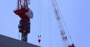 een in beweging kraan Bij de top van de gebouw Bij de bedrijf stad- in tokyo telefoto schot video