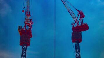 A timelapse of crane at the top of the building in Tokyo telephoto shot tilt video