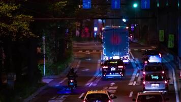 een nacht timelapse van de verkeer jam Bij de stad straat in tokyo telefoto schot zoom video