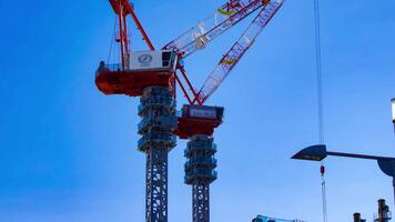 A timelapse of crane at the under construction in Tokyo telephoto shot panning video