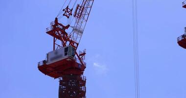 une en mouvement grue à le Haut de le bâtiment à le affaires ville dans tokyo téléobjectif coup video