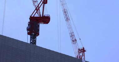 een in beweging kraan Bij de top van de gebouw Bij de bedrijf stad- in tokyo telefoto schot video