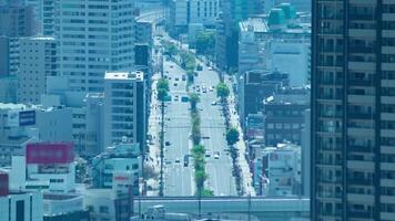 een timelapse van hoog hoek stadsgezicht Bij de stad straat in Osaka telefoto schot zoom video