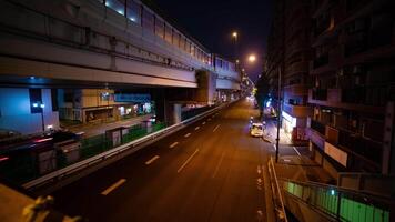 A night timelapse of the traffic jam at the city street under the highway wide shot tilt video