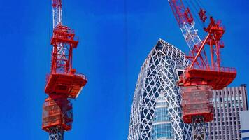 A timelapse of crane at the top of the building in Tokyo telephoto shot tilt video