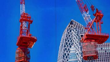 A timelapse of crane at the top of the building in Tokyo telephoto shot zoom video