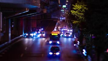 A night timelapse of the miniature traffic jam at the city street in Tokyo tilt video