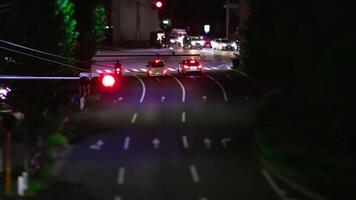 A night timelapse of miniature traffic jam at the city intersection tilt video