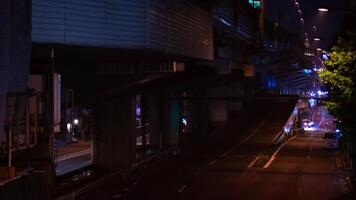 A night timelapse of the traffic jam at the city street under the highway in Tokyo tilt video