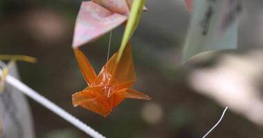 A paper crane swaying in the wind at the traditional street close up video