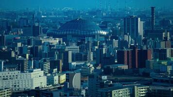 uma crepúsculo espaço de tempo do Alto ângulo paisagem urbana perto Kyocera cúpula dentro Osaka telefoto tiro panning video