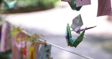 A paper crane swaying in the wind at the traditional street close up video