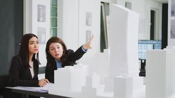 Architectural agency workers taking notes on blueprints, calculating real scale measurements to ensure the perfect elements for the construction team. Women developers studying 3d printed model. video